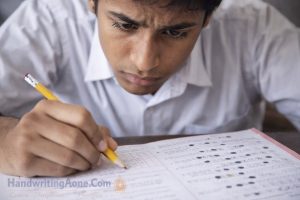 student writing answers carefully during exam showing importance of focus and handwriting clarity