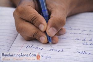close up of student hand holding pen writing notes in notebook during study