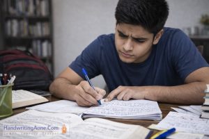 teenage student writing notes carefully in notebook during study time