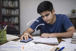 student checking mobile phone while studying from notebook and textbooks