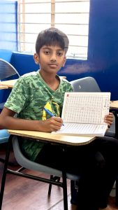 Boy practicing handwriting in classroom at HandwritingAone Vijayanagar Bangalore