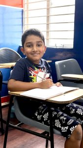 Happy student practicing handwriting with improved confidence Bangalore classes